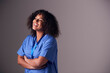 © Monkey Business - Studio Portrait Of Female Nurse Wearing Scrubs Standing Against Grey Background