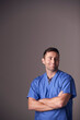 © Monkey Business - Studio Portrait Of Male Nurse Wearing Scrubs Standing Against Grey Background