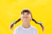 Smart Cutie Girl On A Yellow Background/ Cute Little Girl Smiling On Yellow Background. Happy Small Girl