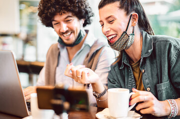 Young milenial influencers sharing creative content on streaming platform - Modern marketing concept with next generation couple having fun on video feed - Vlogging time at coffee bar co working space