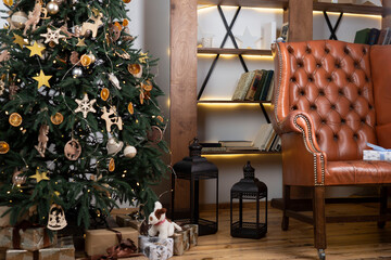 living room interior leather armchair next to christmas tree with gifts, on the background of a bookshelf