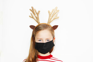 quarantined Santa deer, Beautiful girl red sweater Christmas, and New year gift. The happy small girl in Santa s hat has a Christmas. in a protective black mask on a white background banner, Christmas