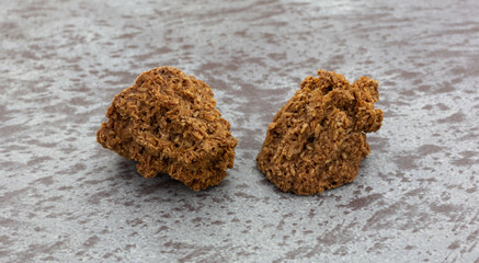 Wall Mural - Side view of two gluten free chocolate macaroons on a gray background.