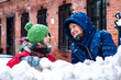 Grandmother with her grandchild sculpts snowballs together. Winter family leisure. Grandmother and grandson granddaughter look in the eye. Grandmother and grandchild face to face outdoors in winter