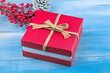 New Year Background! Close up of red christmas gift box and cone on blue wood background