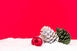 colorful pine cones on red background and snowy backdrop for new year celebration