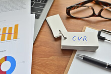 On Top Of The Notebook And Clipboard Is A Wordbook And Pen With The Word CVR Written On It. It Means Conversion Rate.