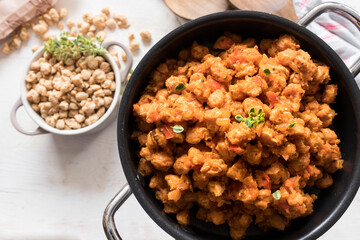 Closeup view of a black casserole full of healthy bolognese soya meat.