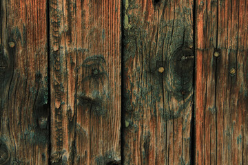 Dark old wooden surface made of separate wooden boards with the remains of paint.