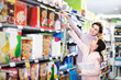 © JackF - Young woman customer with girl looking for breakfast cereal in supermarket. Focus on both persons