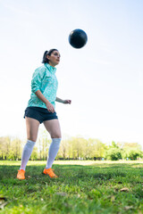 Wall Mural - Young woman practicing soccer skills with ball.