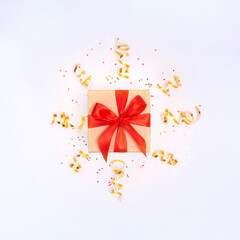 Wall Mural - Gift box with red ribbon, golden confetti and sparkles on white background. Christmas, party, anniversary, birthday present. Flay lay, top view