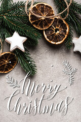 Canvas Print - Top view of dried orange slices, cookies and pine branch near merry christmas lettering on textured 