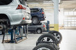 Modern workshop with automobiles raised on car lifts on blurred