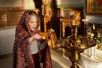 Religious girl with covered head praying in Christian Church