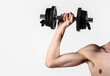 © Yevhen - Man hand holding dumbbell in hand. Skinny guy hold dumbbells up in hands. A thin man in sports with dumbbells. Weak hand man lift a weight, dumbbells. Nerd maleraising a dumbbell