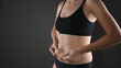 © Tatsiana - Woman in black underwear holding her fat belly, stomach with hands, diet, weight loss and liposuction concept. Isolated on grey background