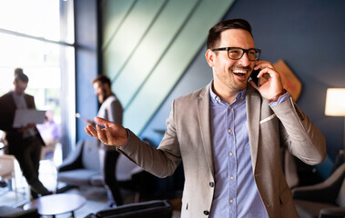 Enjoying his work. Happy young successful businessman talking on the mobile phone