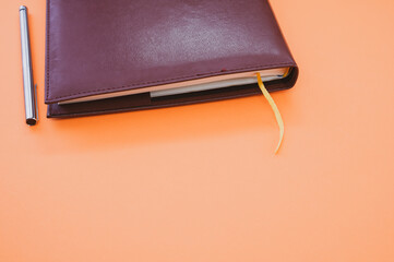 Sticker - Top view closeup of a grey notebook with a yellow bookmark isolated on an orange background