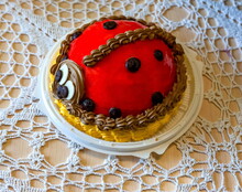 Festive Red Cake "ladybug" On The Background Of Knitted Tablecloth