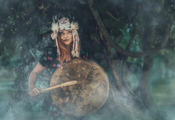 Wall Mural - beautiful shamanic girl playing on shaman frame drum in the nature.