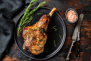 Wall Mural - BBq Roasted goat leg. Farm meat. Dark Wooden background. Top view