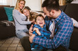 © Mediteraneo - Happy family with kids playing at home. Family sitting on floor and playing together.
