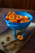 Fresh Apricots, Whole And Pitted In A Blue Colander