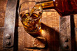 © Foodlovers - Bourbon pouring into rocks glass on a bourbon barrel