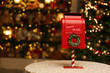 red mailbox for letters to santa claus on the background of a glowing christmas tree