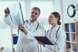 © freeograph - Male doctor showing woman x-ray in office.