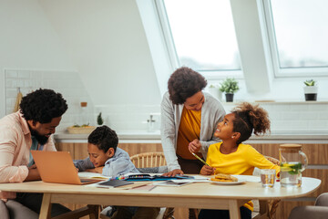 Wall Mural - Afro parents helping their children with his homework at home