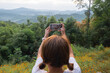 Cute girl taking pictures of forest mountain scenery beautiful light moment