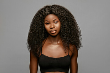 Wall Mural - beauty fashion portrait of young beautiful african american woman with volume,curly hair against gra