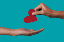 Person Giving A Heart To Another Person