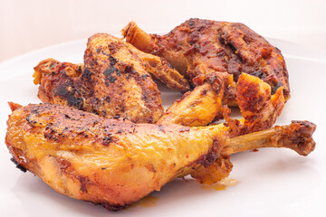 Golden crispy roasted chicken legs and wings with skin macro close up shot pan fried