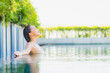 © siraphol - Portrait beautiful young asian woman relax smile leisure around outdoor swimming pool