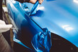 © hedgehog94 - Car wrapping specialist putting vinyl foil or film on car. Selective focus.