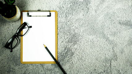 Wall Mural - A notebook with pencil and eye glasses on the desk. - Business concept.