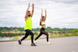 © Georgii - Young sporty couple doing lunges together outdoor, man and woman working out outside, fitness exercise with partner