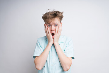 A surprised caucasian boy on a white background