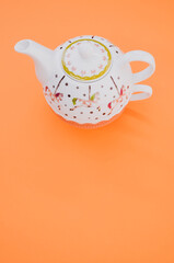 Sticker - Vertical shot of decorative teapot isolated on an orange background