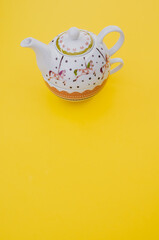 Sticker - Vertical shot of decorative teapot isolated on yellow background