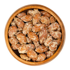 Wall Mural - Candied almonds in a wooden bowl. Homemade, in a special way cooked almonds, whole nuts coated in crunchy sugar. Sold at Christmas markets. Close-up, from above, isolated over white, macro food photo.