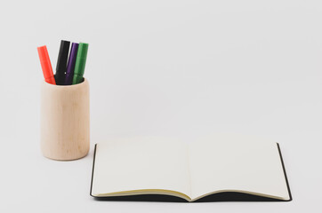 Canvas Print - Closeup shot of an open blank book with a marker holder on a white background