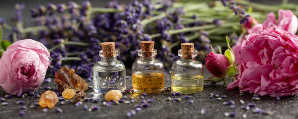 Panoramic header of essential oil bottles, lavender, frankincense and roses