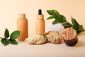 Composition from the natural materials and wooden cosmetics containers near it.Fresh green leafs on the background.Concept of the natural organic components.Advertising banner.Pastel colors.