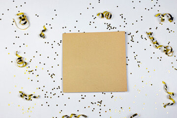 Glitter stars, golden confetti and vintage yellow textured paper on white background. Flat lay. Party time concept.