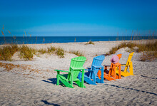 Troical Colored Beach Chairs Awaiting The Dramatic Sunset In Florida's Gulf Coast