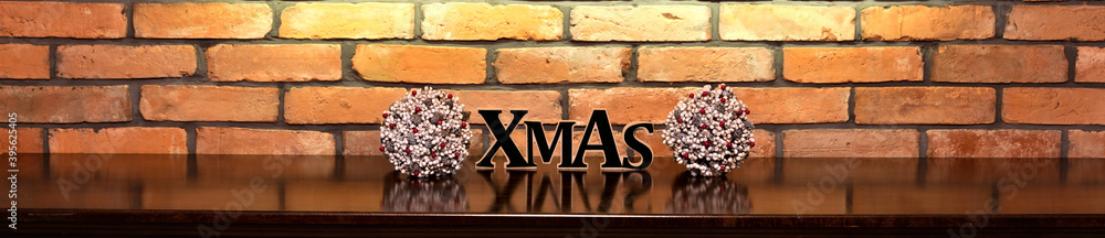 Xmas inscription and Christmas decorations on the background of an old brick wall.

 - obrazy, fototapety, plakaty 